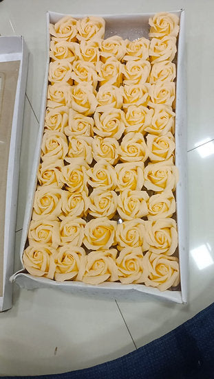 Box of artificial scented soap foam roses in soft yellow, arranged in rows