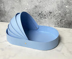 bassinet-shaped gift basket with a teddy bear, foil chocolates, and white and blue flowers, decorated with an "It's a Boy" ribbon for a baby shower gift