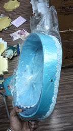bassinet-shaped gift basket with a teddy bear, foil chocolates, and white and blue flowers, decorated with an "It's a Boy" ribbon for a baby shower gift